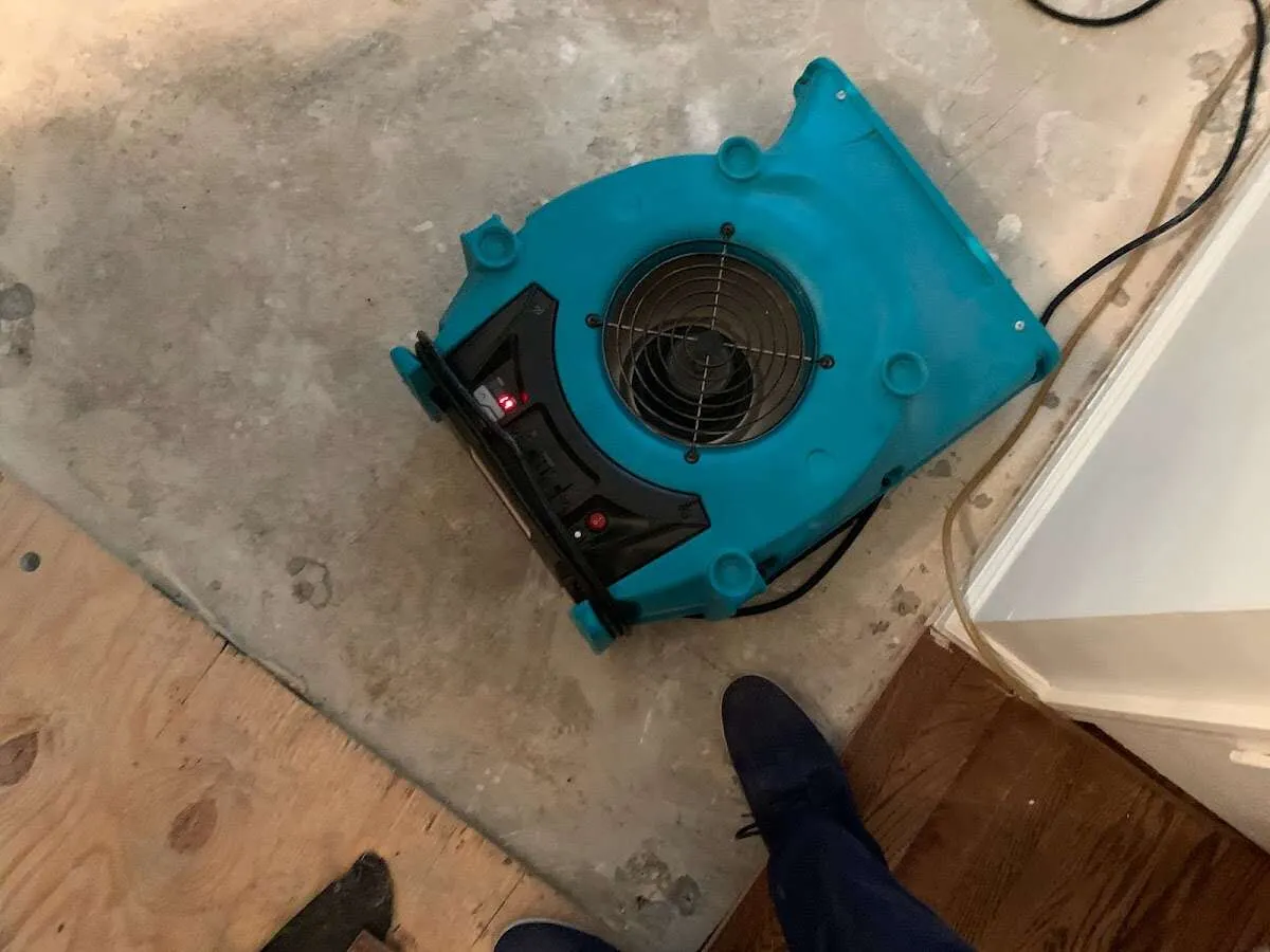 Air mover drying subfloor during Commercial Water Damage Restoration in Sand Springs